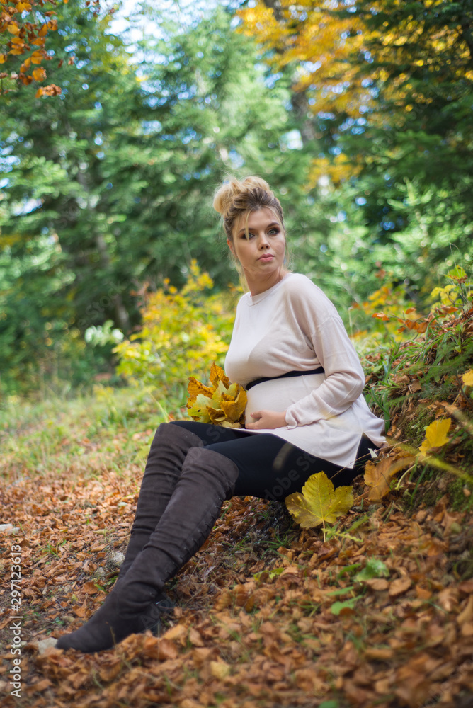 Young pregnant woman in nature enjoying autumn sun outdoors. Young pregnant woman in nature enjoying autumn sun outdoors.
