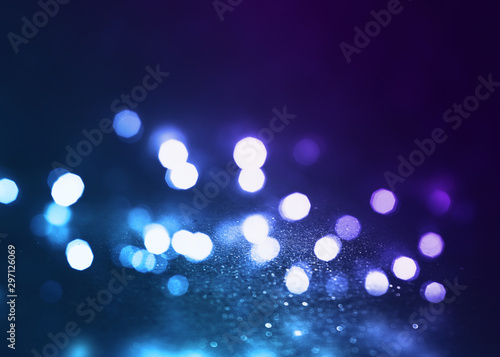 Abstract background. Dark empty stage, multi-colored rays of a neon searchlight, wet asphalt, smoke, night shooting, bokeh color.