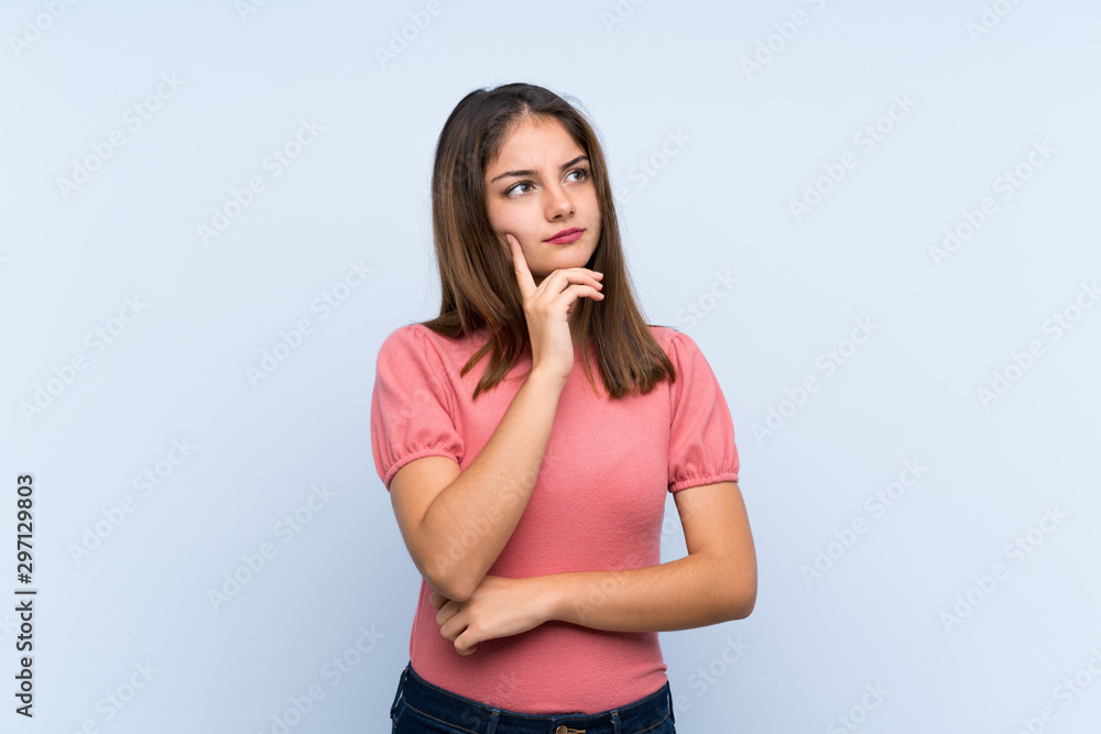 Young brunette girl over isolated blue background thinking an idea Young brunette girl over isolated blue background thinking an idea
