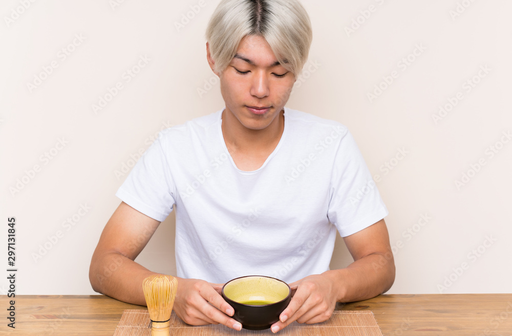 Young asian man with matcha tea in a table Young asian man with matcha tea in a table