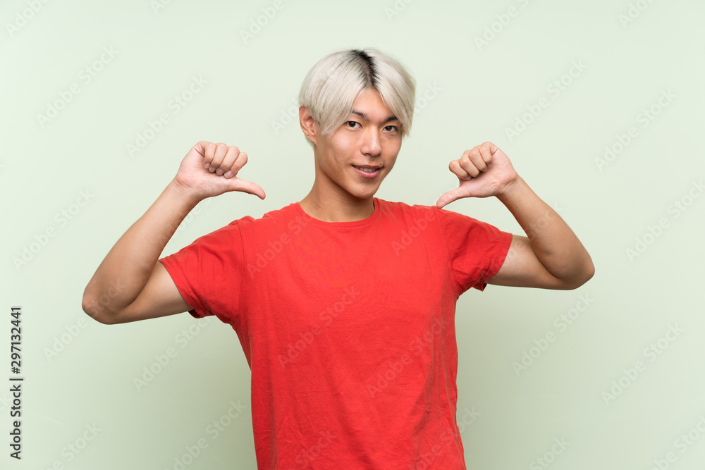 Fototapeta premium Young asian man over isolated green background proud and self-satisfied