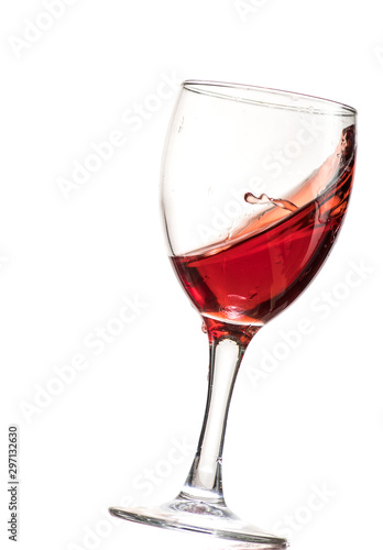 a splash of red wine in a glass on a white background