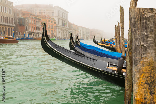 Gondolas moored by Saint Mark square in a foggy morning © Stavros