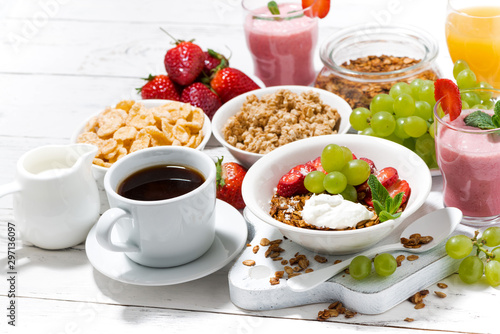 delicious and healthy breakfast with fruits, granola and milkshake on white background