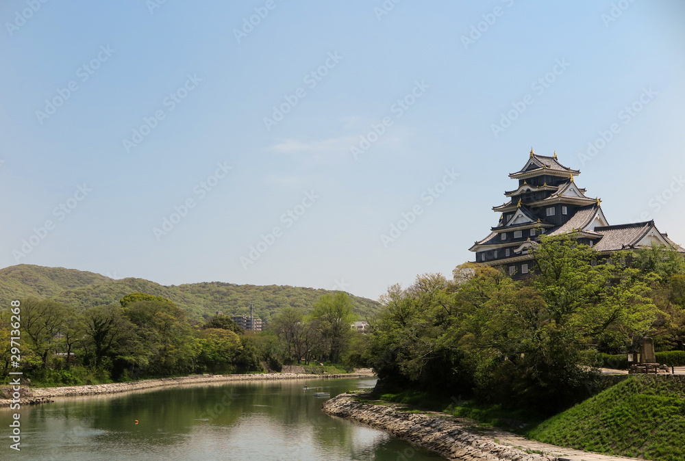 The big castle located near the river with beautiful mountain and forest view in front the building in Japan. The big castle located near the river with beautiful mountain and forest view in front the building in Japan.
