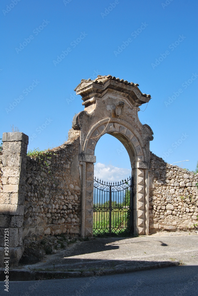 Antica porta con cancello e muro in pietra Antica porta con cancello e muro in pietra