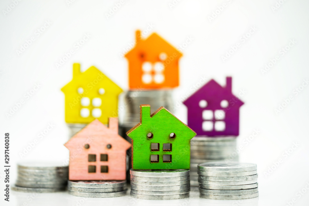 Mainature people standing with coins stack and home.  Home financial investment Concept.