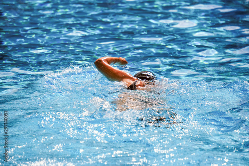 Detailansicht RÃ¼cken: Junge Schwimmerin trainiert konzentriert im Schwimmbecken im Freibad â€“ selektiver Fokus