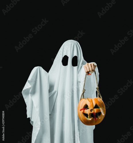 Ghost holding trick-or-treat pumpkin basket with candy in Halloween. © Alex Photo