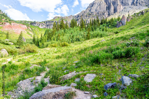 View of colorful green alpine rocky meadow with rocks and wildflowers on trail to Ice lake near Silverton, Colorado on summit in August 2019 summer