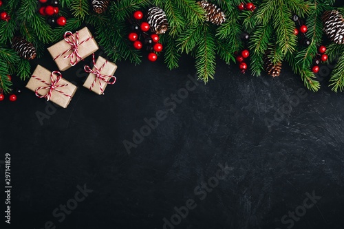 Christmas tree decoration background with fir cones,  red berries and presents.