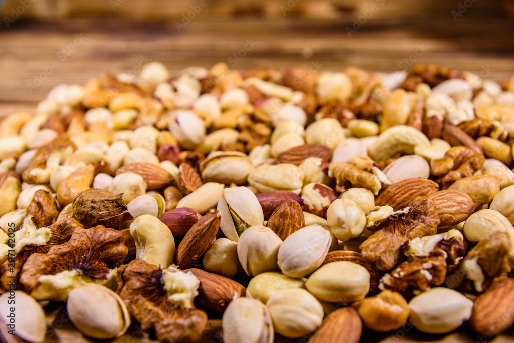 Background of the various nuts (almond, cashew, hazelnut, pistachio, walnut) a wooden table. Vegetarian meal. Healthy eating concept