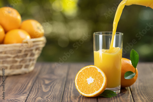 Bild auf Leinwand orange juice pouring in glass