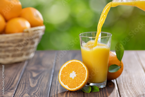 Bild auf Leinwand orange juice pouring in glass