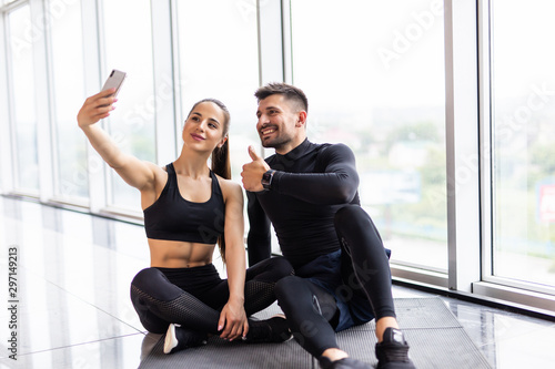 Young fitness couple taking a sefie in a gym photo