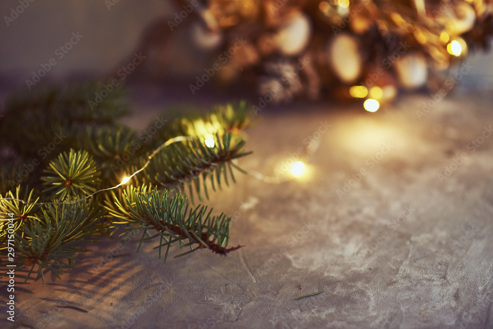 Christmas decorations with garland lights and fir tree branch on a dark background