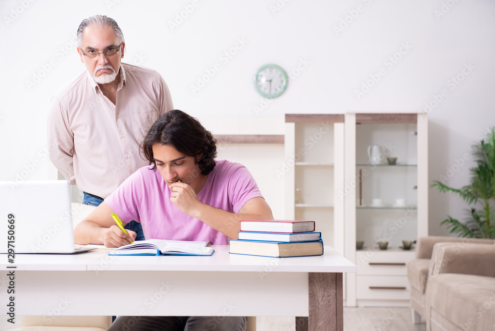 Old father helping his son in exam preparation Old father helping his son in exam preparation