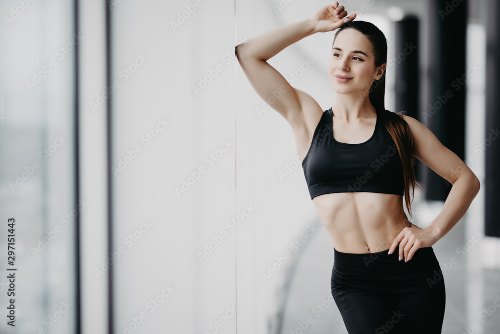 Sporty muscular fitness woman standing in gym. Health concept.