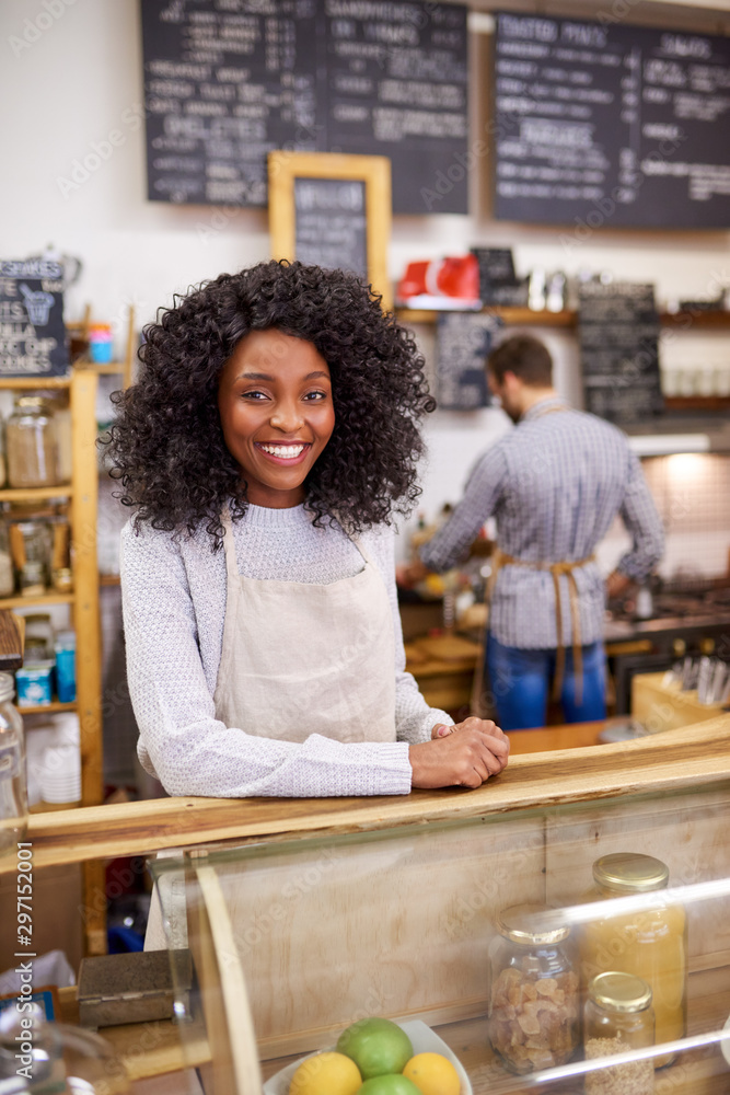 © marvent - Smiling young African American barista working at a cafe counter