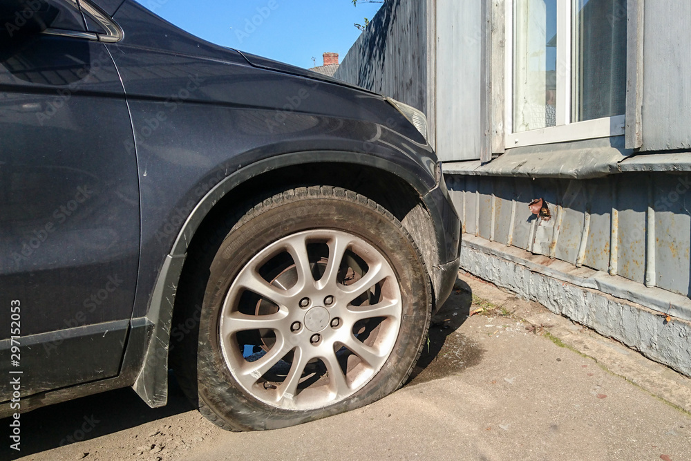 a traffic accident on a city street, a car with a broken and empty tire