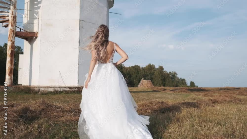 Attractive girl in a beautiful white dress runs in nature, the wind develops hair Attractive girl in a beautiful white dress runs in nature, the wind develops hair
