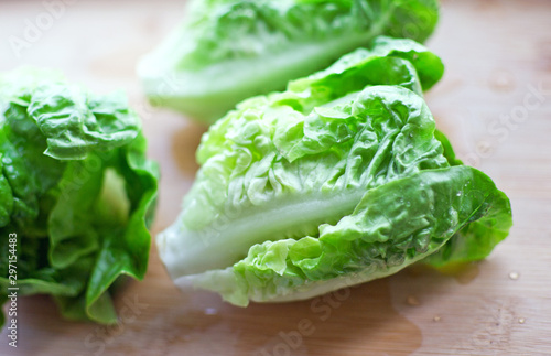 Fresh washed bundle of Romaine lettuce on the wooden cutting board