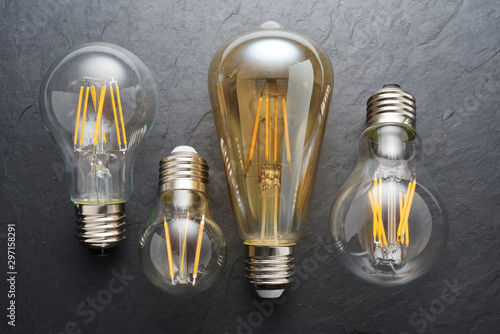 Transparent LED filament light bulbs on black background.