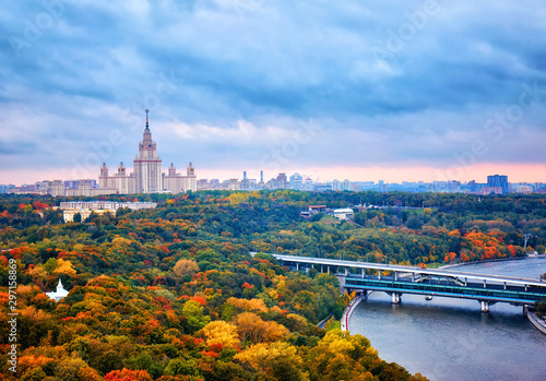 Rainy sunset clouds above river, park, bridge, ships and large city landscape of Moscow
