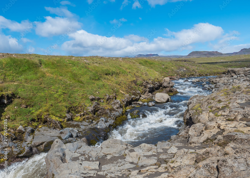 Beautiful lush green Landscape of Skoga river valley cascades near Skogafoss waterfall and Skogar end of Fimmvorduhals hiking trail. South Iceland, Summer blue sky Beautiful lush green Landscape of Skoga river valley cascades near Skogafoss waterfall and Skogar end of Fimmvorduhals hiking trail. South Iceland, Summer blue sky