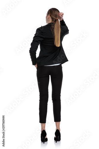 businesswoman standing with hand in pocket and scratching head