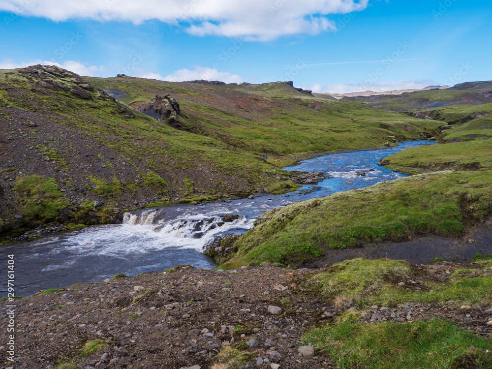 Beautiful lush green Landscape of Skoga river valley cascades near Skogafoss waterfall and Skogar end of Fimmvorduhals hiking trail. South Iceland, Summer blue sky Beautiful lush green Landscape of Skoga river valley cascades near Skogafoss waterfall and Skogar end of Fimmvorduhals hiking trail. South Iceland, Summer blue sky