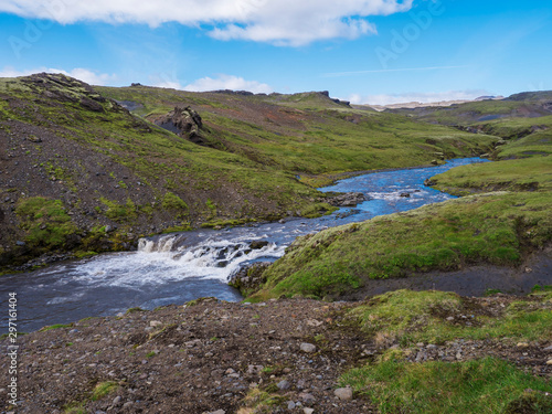 Beautiful lush green Landscape of Skoga river valley cascades near Skogafoss waterfall and Skogar end of Fimmvorduhals hiking trail. South Iceland, Summer blue sky