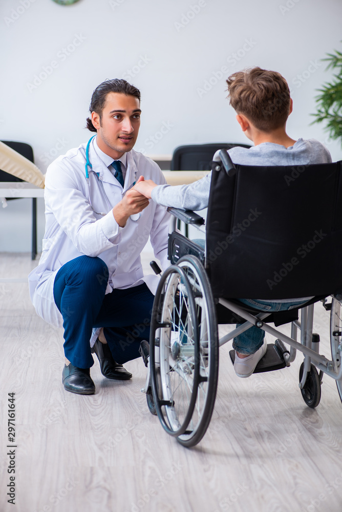 Young male doctor pediatrist and boy in wheel-chair Young male doctor pediatrist and boy in wheel-chair