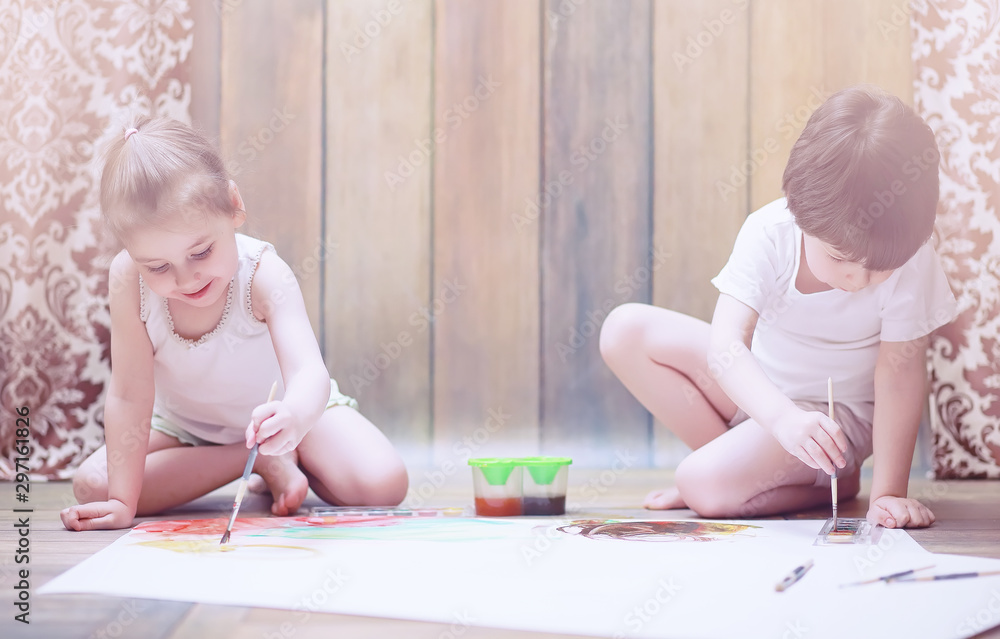 Little children paint on a large sheet of paper Little children paint on a large sheet of paper