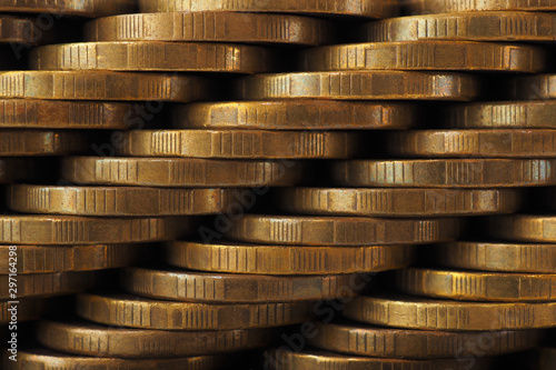 A wall of stacks of coins. Dark wallpaper. Macro