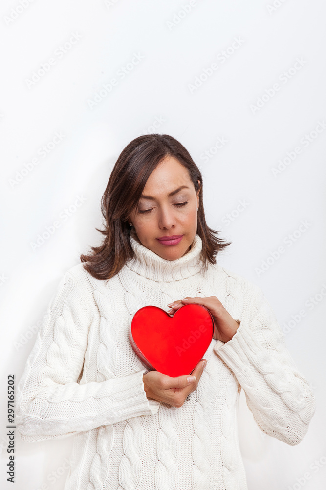 Beautiful sad woman holding a red heart on her hands isolated on white background.. Conceptual for heartbreak, cardiology. Beautiful sad woman holding a red heart on her hands isolated on white background.. Conceptual for heartbreak, cardiology.