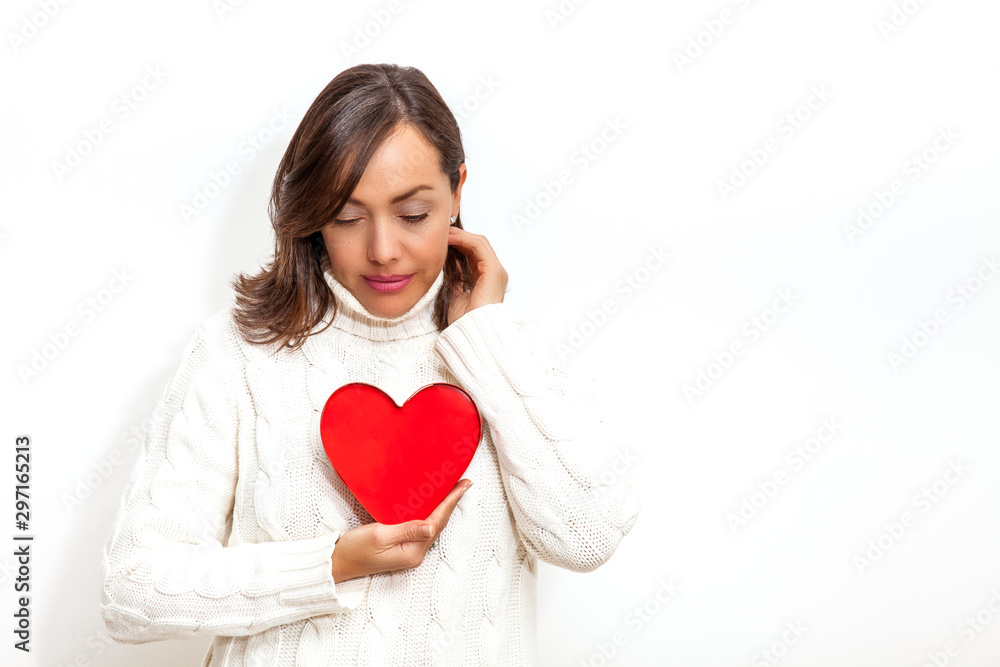 Beautiful sad woman holding a red heart on her hands isolated on white background.. Conceptual for heartbreak, cardiology. Beautiful sad woman holding a red heart on her hands isolated on white background.. Conceptual for heartbreak, cardiology.