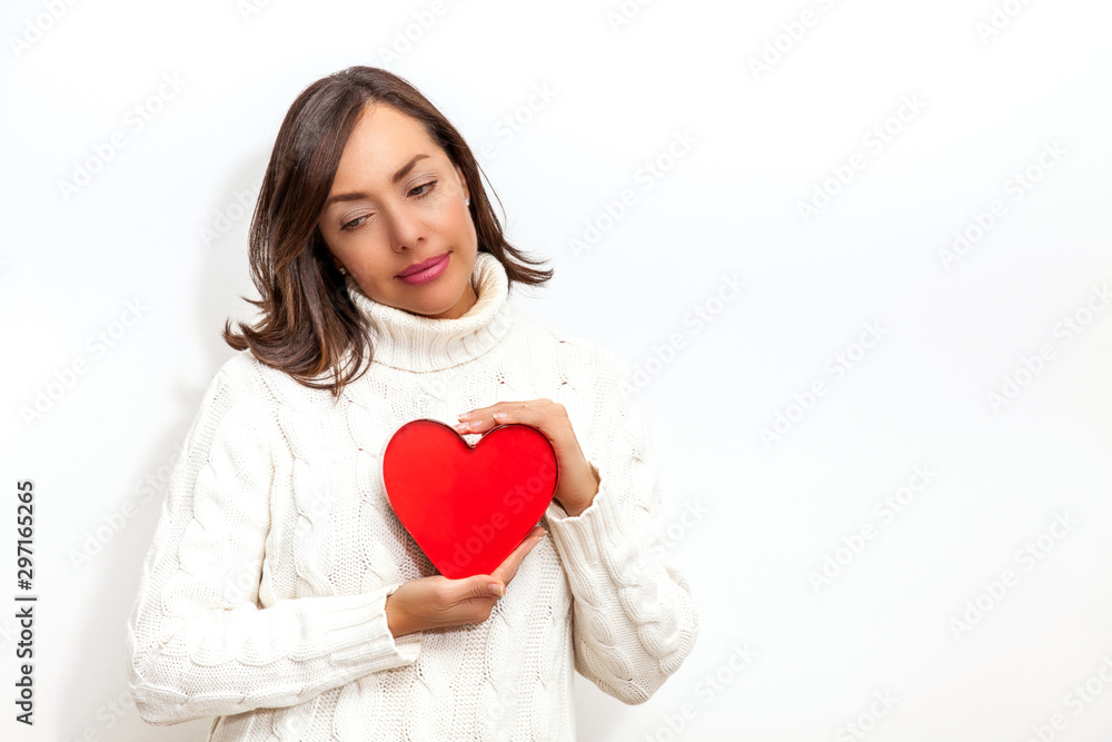 Beautiful sad woman holding a red heart on her hands isolated on white background.. Conceptual for heartbreak, cardiology. Beautiful sad woman holding a red heart on her hands isolated on white background.. Conceptual for heartbreak, cardiology.