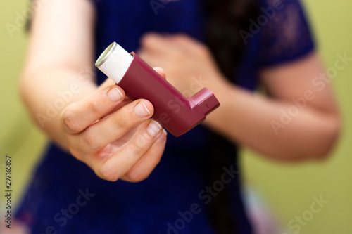 Girl suffering asthma attack reaching inhaler photo