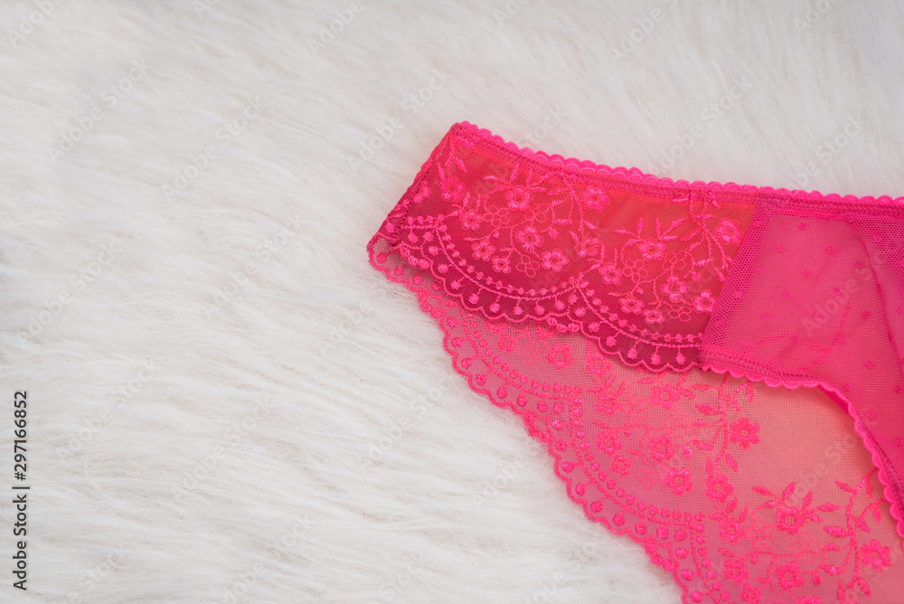 Part of lacy bright pink panties on white fur. Close up. Fashionable  concept of lingerie Stock Photo