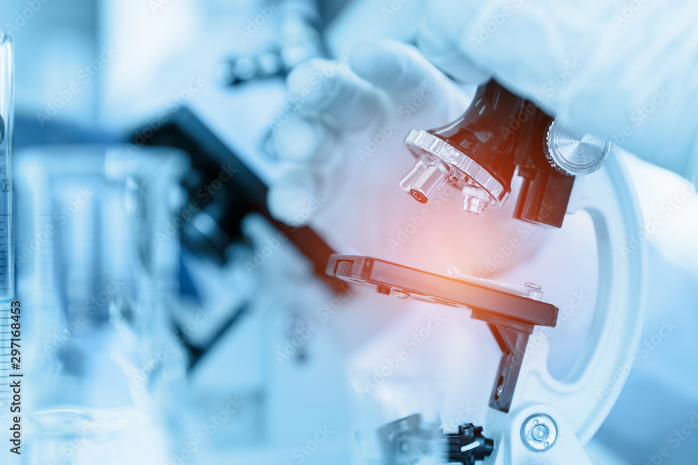 Healthcare and medicine concept, Close Up Scientist using microscope in laboratory room while making medical testing and research Healthcare and medicine concept, Close Up Scientist using microscope in laboratory room while making medical testing and research