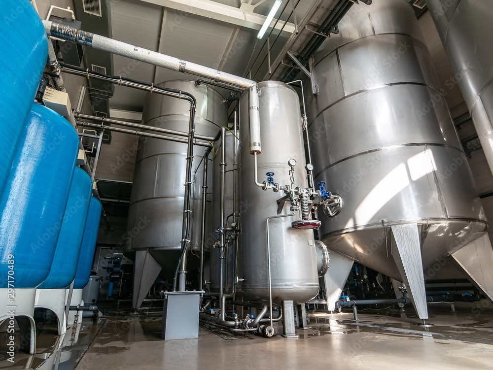 Drinking water factory or plant production, industrial interior. Large metal tanks for filtering and potable water treatment from well Drinking water factory or plant production, industrial interior. Large metal tanks for filtering and potable water treatment from well