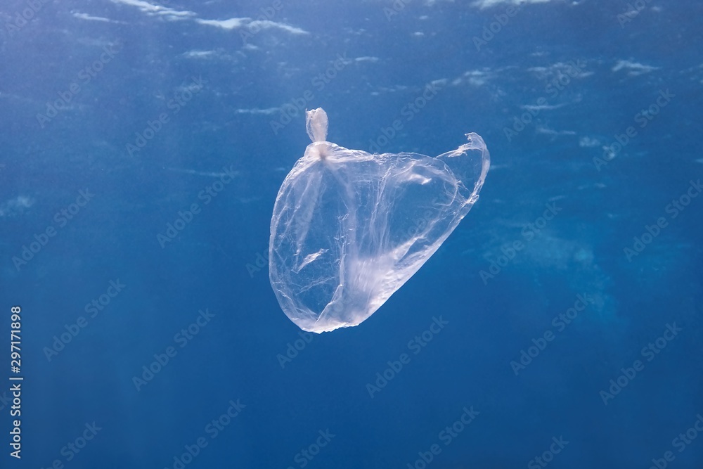 Plastic bag floating in the blue sea water. World ocean contaminated by plastic. Environment pollution concept. Plastic bag floating in the blue sea water. World ocean contaminated by plastic. Environment pollution concept.