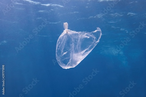 Plastic bag floating in the blue sea water. World ocean contaminated by  plastic. Environment pollution concept.