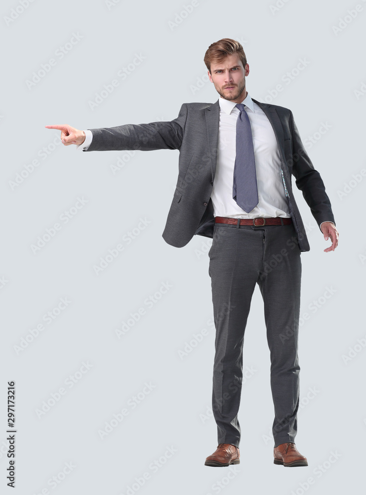 in full growth. serious businessman pointing to the side. in full growth. serious businessman pointing to the side.