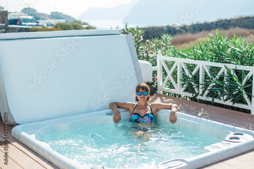Girl is relaxing in the jacuzzi outside. Luxury life resting.