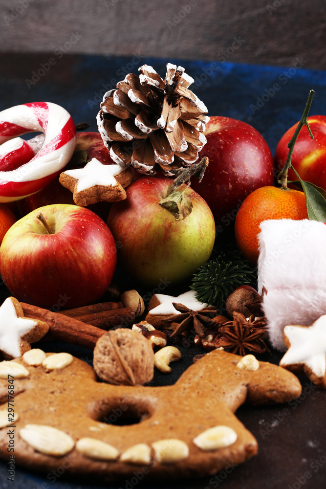 christmas cookies and santa had with spieses, nuts and fruits on rustic table christmas cookies and santa had with spieses, nuts and fruits on rustic table