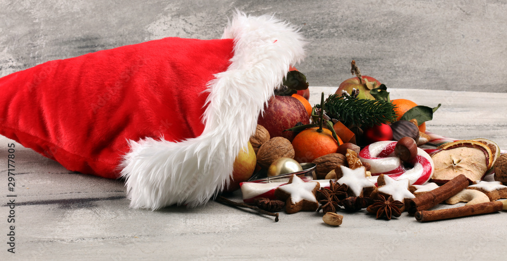 Obraz premium christmas cookies and santa had with spieses, nuts and fruits on rustic table