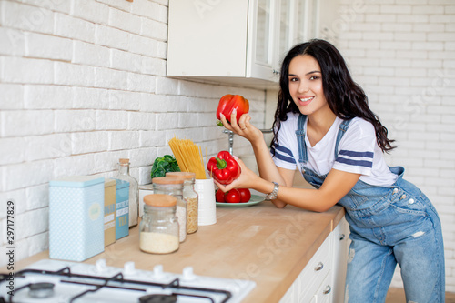 Girl in kitchen preparing vegetables and fruits in pajamas
