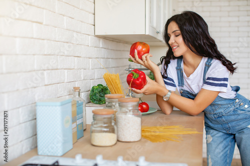 Girl in kitchen preparing vegetables and fruits in pajamas